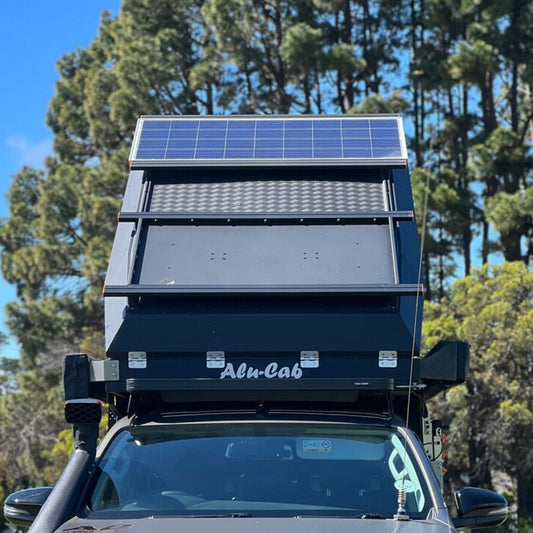 Alu-Cab Dachkorb in schwarz und Solarpanel montiert auf einem Dachzelt. Der Dachkorb kann Ausrüstung transportieren.