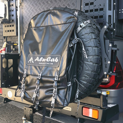 Schwarze Alu-Cab Reserveradtasche wurde an dem Reserverad befestigt, welches an einem ModCAP an der Hecktür hängt.