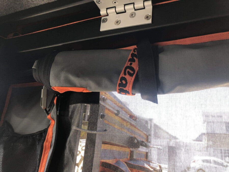 Moskitonetz mit einer Canvas-Stoffschicht wurde in dem Seitenfenster des Alu-Cab ModCAP´s gespannt. Es schützt vor Insekten, während es frische Luft in den Camper lässt. Das Canvas wurde nach oben aufgerollt.