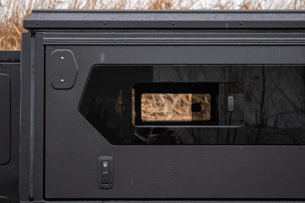 ModCAP Worker für Doppelkabine und Extrakabine montiert auf einem Pick-Up. Detailbild von einem Seitenfenster der Base mit geöffnetem Schiebefenster.